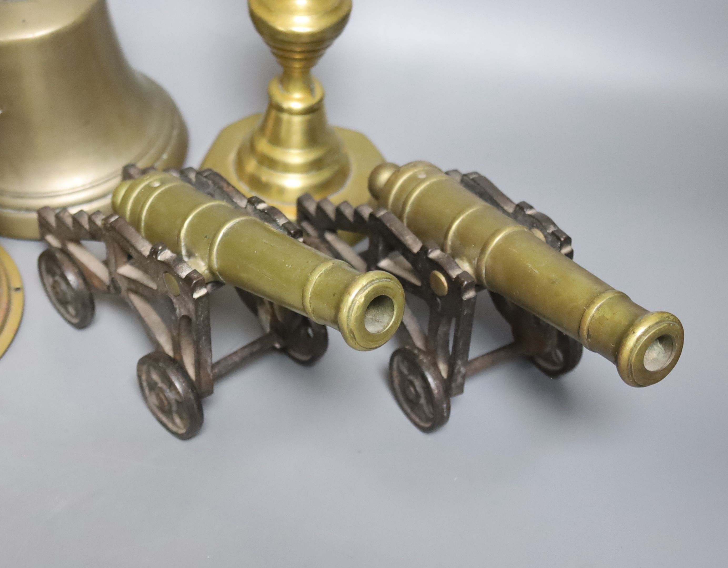 A quantity of brassware including bells, model cannons, candlesticks etc.